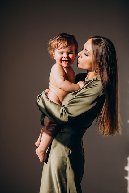 Joven madre hermosa con su hijo pequeño, practicando la lactancia materna