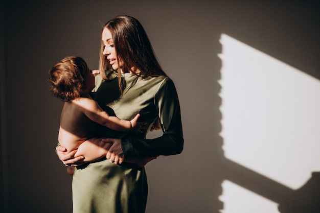 Joven madre hermosa con su hijo pequeño, practicando la lactancia materna