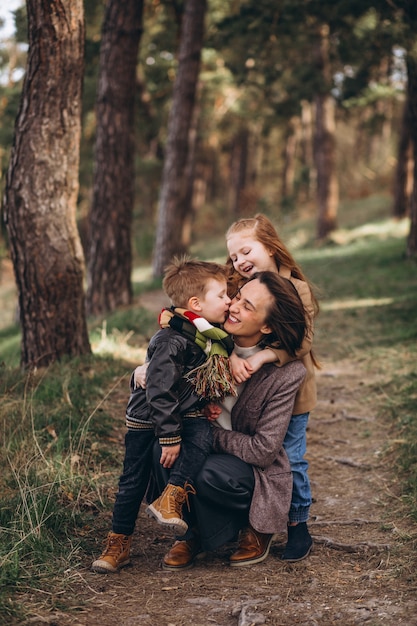 Joven madre con hija e hijo en el bosque