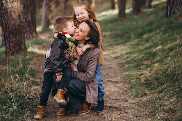 Joven madre con hija e hijo en el bosque