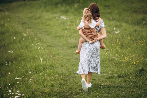 Joven madre con hija pequeña en el parque