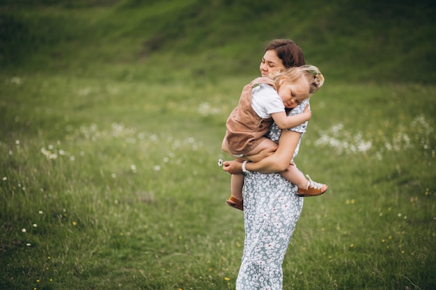 Joven madre con hija pequeña en el parque