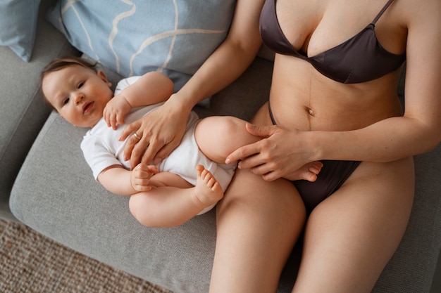 Foto gratuita joven madre pasando tiempo con el bebé