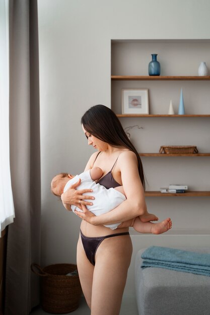 Foto gratuita joven madre pasando tiempo con el bebé