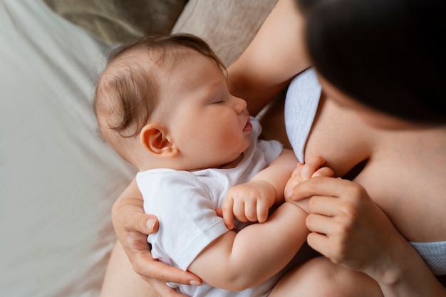 Foto gratuita joven madre pasando tiempo con el bebé