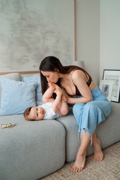 Foto gratuita joven madre pasando tiempo con el bebé