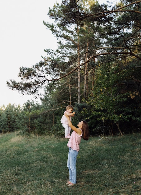 Joven madre con su adorable bebé en el bosque