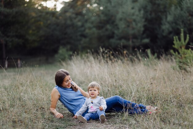 Joven madre con su adorable bebé en el bosque