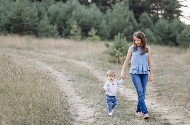 Joven madre con su adorable bebé en el bosque