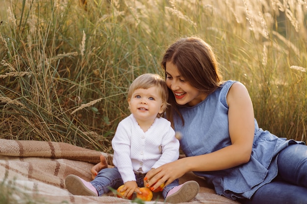 Joven madre con su adorable bebé en el bosque