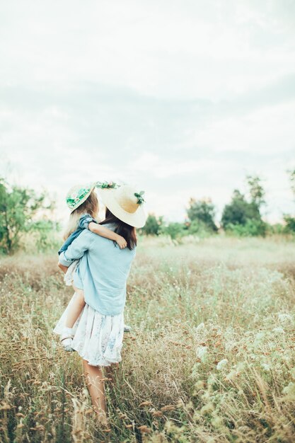 La joven madre y su hija en la hierba verde