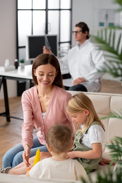 Joven madre con sus hijos en una cita con el pediatra