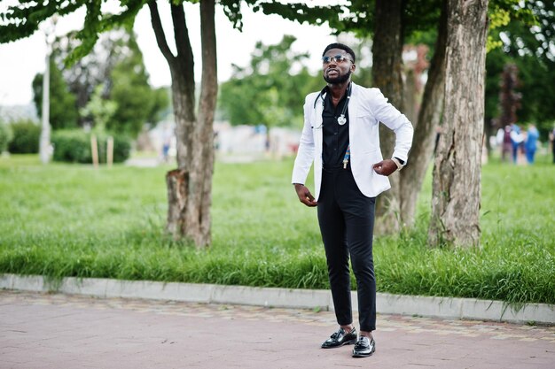 Joven médico afroamericano con un estetoscopio posado al aire libre