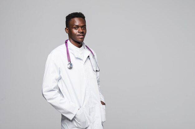 Joven médico afroamericano en uniforme blanco aislado sobre fondo blanco de pie con los brazos en busca de profesionales y altamente competentes en el campo de la especialización médica