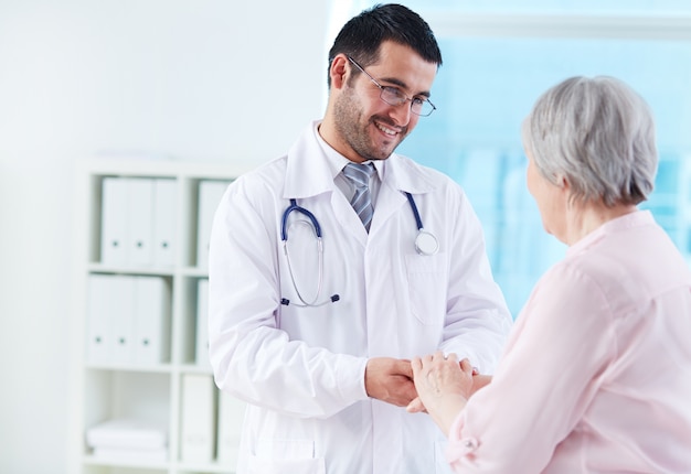 Foto gratuita joven médico apoyando su paciente