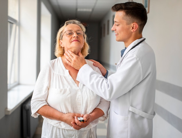 Joven médico consulta mujer senior