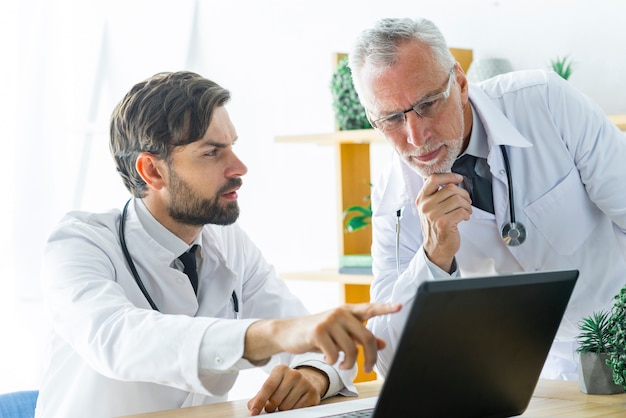 Joven médico consultoría con colega senior