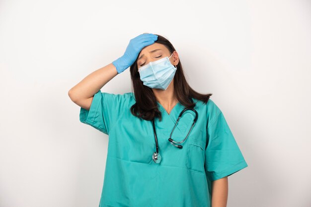 Joven médico con dolor de cabeza sobre fondo blanco. Foto de alta calidad