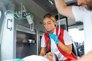 Foto gratuita joven médico con estetoscopio escuchando el corazón y los pulmones del paciente