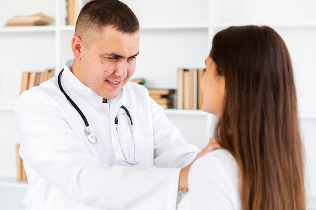 Joven médico examinando el cuello de la mujer