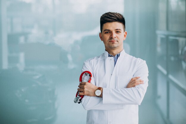 Joven médico guapo en una túnica médica con estetoscopio