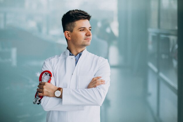 Joven médico guapo en una túnica médica con estetoscopio