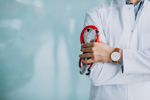 Joven médico guapo en una túnica médica con estetoscopio