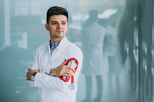 Joven médico guapo en una túnica médica con estetoscopio