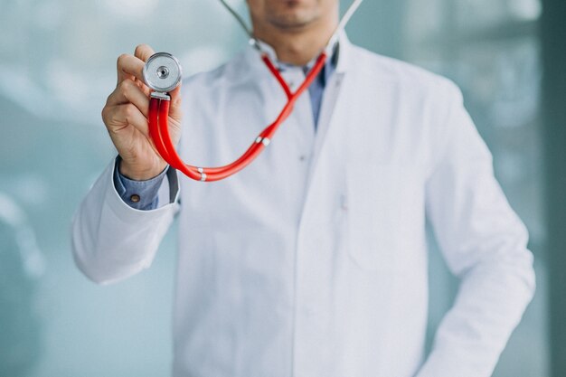 Joven médico guapo en una túnica médica con estetoscopio