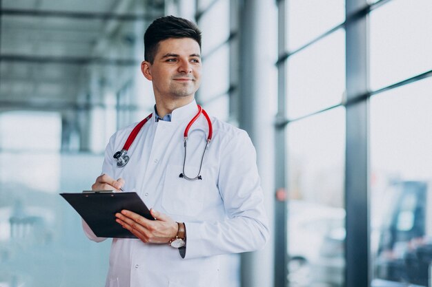 Joven médico guapo en una túnica médica con estetoscopio