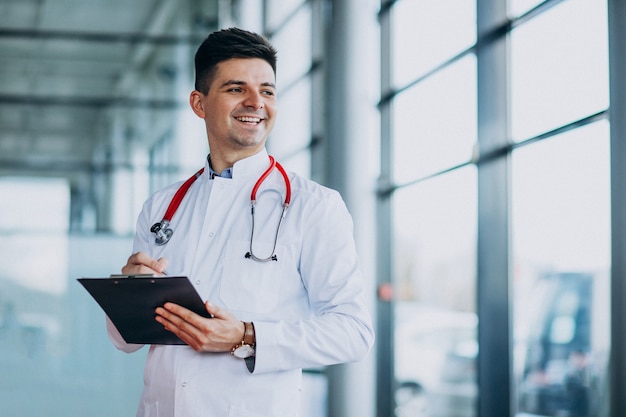 Joven médico guapo en una túnica médica con estetoscopio