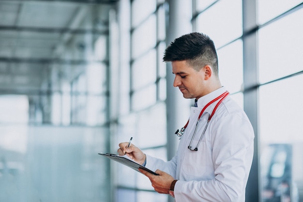 Joven médico guapo en una túnica médica con estetoscopio