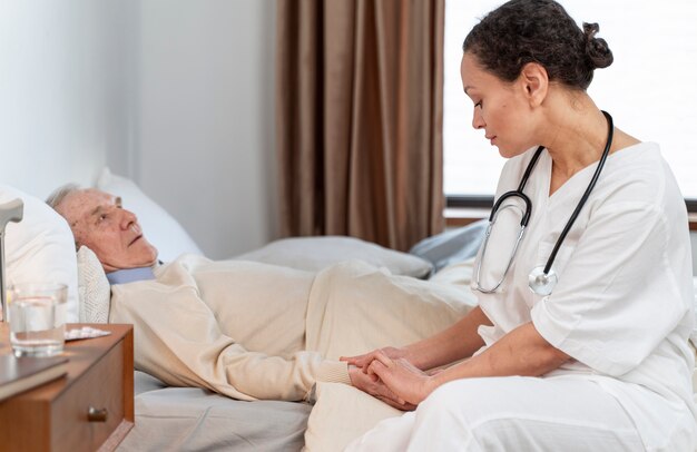 Joven médico hablando con su paciente senior