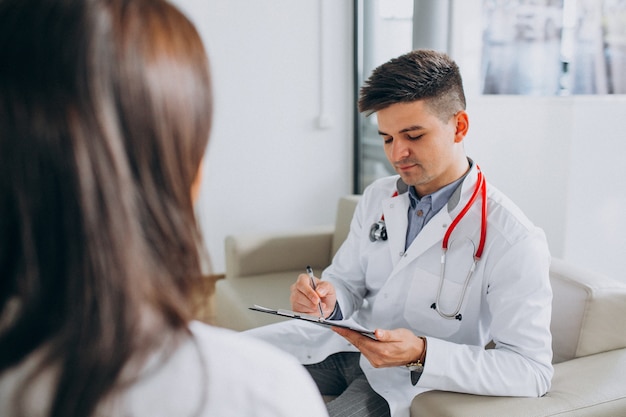 Joven médico masculino con paciente en el hospital