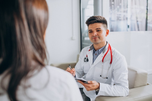 Joven médico masculino con paciente en el hospital