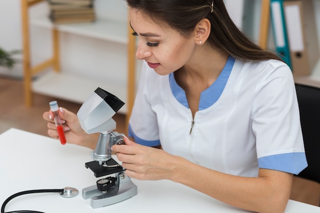 Joven médico mirando una muestra de sangre