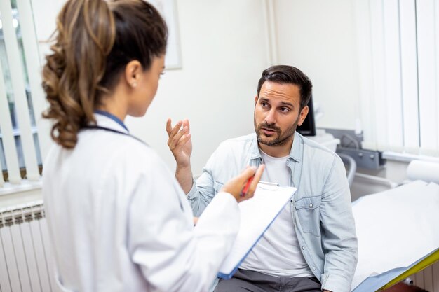 Joven médico profesional médico consultando al paciente hablando con un cliente adulto en el chequeo médico visita tratamiento de enfermedades concepto de atención médica