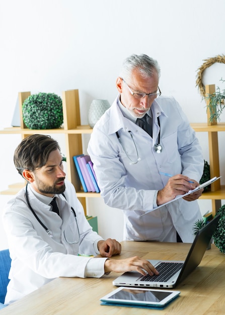 Joven médico que muestra datos a colega senior