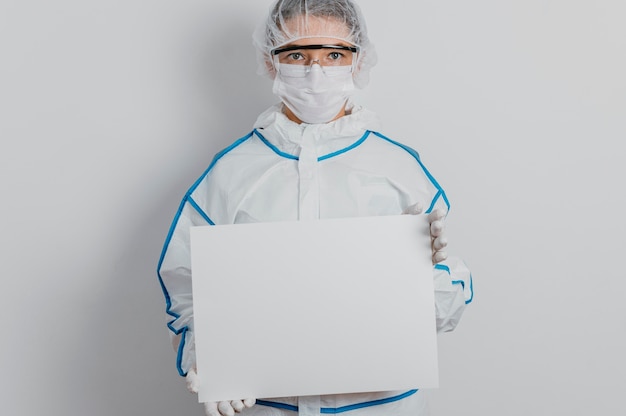 Joven médico sosteniendo un cartel en blanco