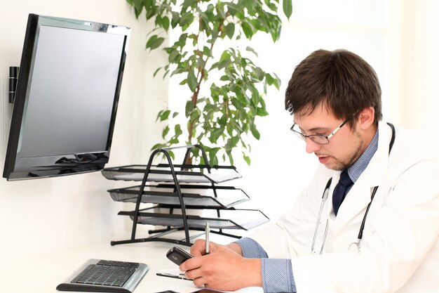 Joven médico trabajando en su oficina