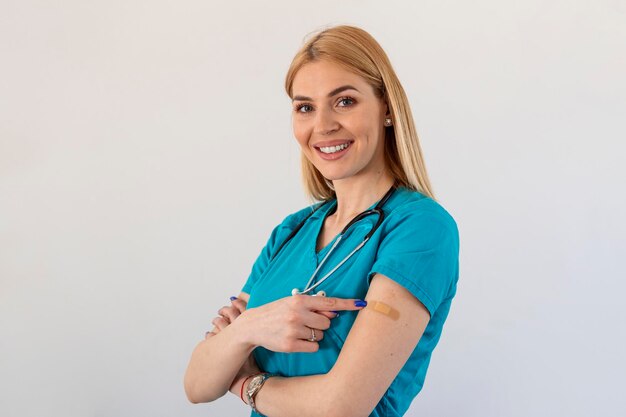 Joven médico vacunado trabajador médico enfermera mujer gesticulando ThumbsUp aprobando vacunación fondo blanco.