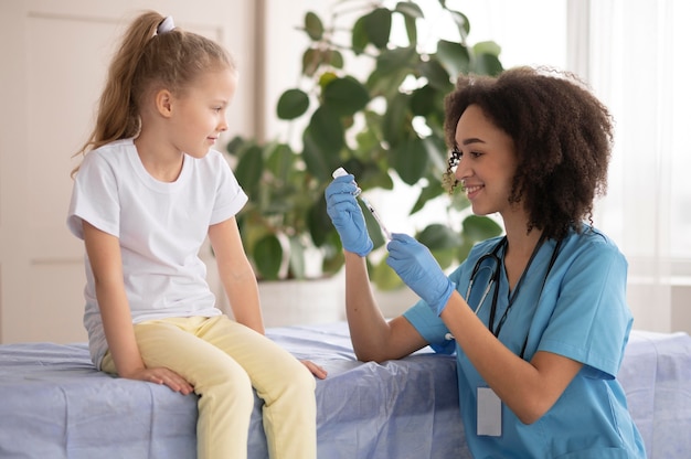 Foto gratuita joven médico vacunando a una niña