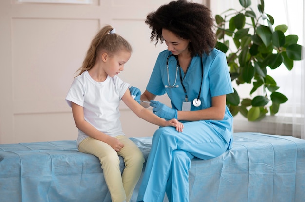 Joven médico vacunando a una niña