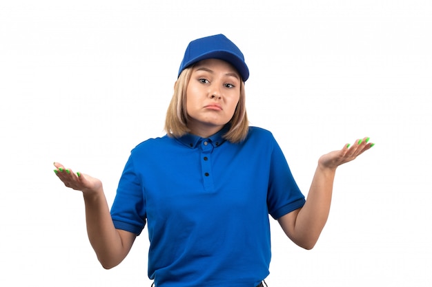 Una joven mensajero de vista frontal en uniforme azul posando con expresión de disgusto