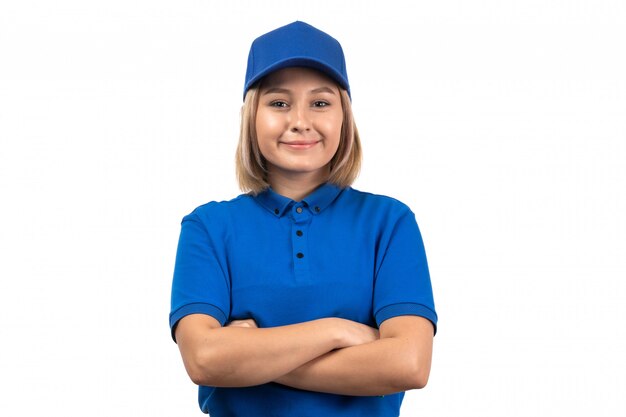 Una joven mensajero de vista frontal en uniforme azul posando con una sonrisa en su rostro
