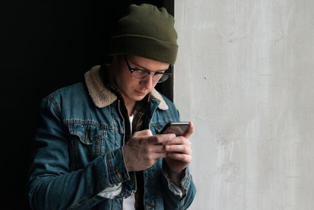 Joven mirando su teléfono con espacio de copia