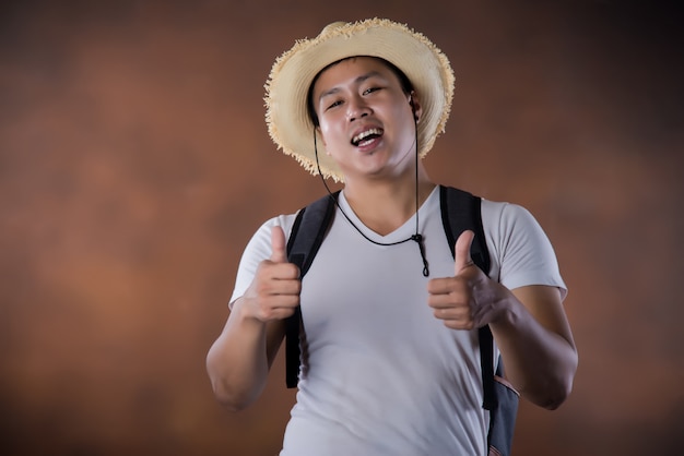 Joven mochilero que viaja asiático con bolsa y sombrero