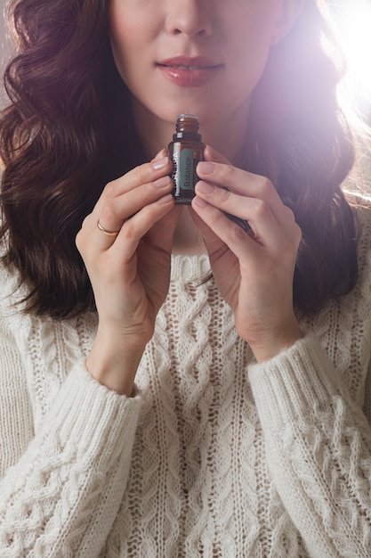 Foto gratuita joven modelo caucásico con cabello largo oscuro posa para la cámara con la mano cerca de su rostro