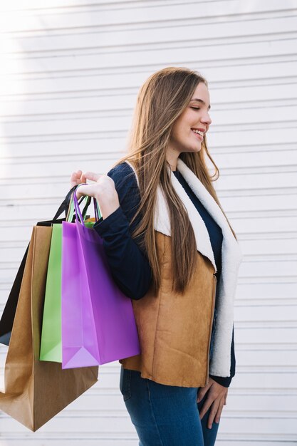 Joven modelo encantador con bolsas de compras