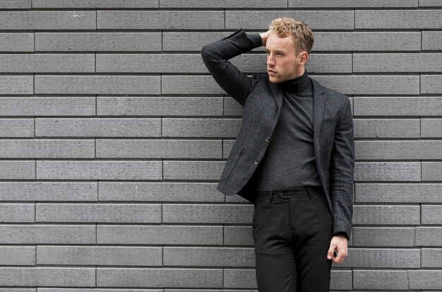 Joven modelo posando cerca de una pared gris